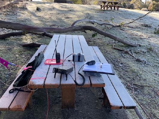 
        Frost on park bench with tranceiver, clipboard for logs and associated station accessories setup
      